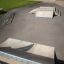 Allestimento di rampa e rail per skatepark Rail 25/60 su pavimentazione in cemento vicino a un edificio in mattoni.