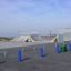Rampe e rail dello skate park con dissuasori blu e cestini verdi.