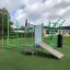 Attrezzatura fitness all'aperto New Age Fit con varie postazioni per l'allenamento su un campo erboso.