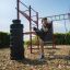 Uomo che pratica calci su attrezzatura fitness all'aperto New Age Fit.