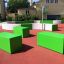 Panchine verdi e strutture da gioco di Multiarena in un parco giochi.