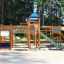 Space Station castle with slide in un parco giochi circondato da alberi.