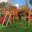 Space Station castle with slide in un contesto di parco giochi.