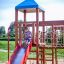 Bambino che scende dallo scivolo rosso dell'attrezzatura da parco giochi Space Station castle with slide.