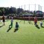 Bambini che giocano in un campo sportivo Multiarena in una giornata di sole.