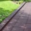 Rubber Tiles 55 pavimentazione di sicurezza installata lungo il sentiero del giardino vicino all'erba e alle piante