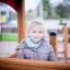 Bambina che gioca all'interno di un Villa Maxi sandbox with a playhouse.