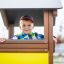 Bambino che gioca all'interno del Villa Maxi sandbox with a playhouse.
