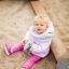 Un bambino piccolo seduto nel Villa Maxi sandbox with a playhouse.