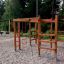 Chimpanzee wooden playhouse in un parco giochi circondato da alberi.
