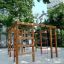 Chimpanzee wooden playhouse in un parco giochi circondato da alberi.