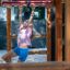 Una bambina che gioca su un Chimpanzee wooden playhouse.
