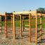 Casetta Activity Center in legno con strutture da arrampicata in un parco giochi.