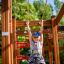 Bambino che gioca su Activity Center wooden playhouse