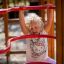 Bambino che gioca su Activity Center wooden playhouse.