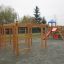 Activity Center wooden playhouse con strutture da arrampicata e scivolo in un parco giochi