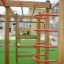 Casetta Activity Center in legno con strutture da arrampicata e scivoli.