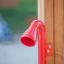 Attrezzatura da gioco Megaphone rossa fissata a una struttura in legno.