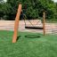 Altalena da parco giochi in legno 'BNS Single Swing Robinia 2 Posts' sull'erba.