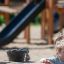 Un bambino che gioca con l'attrezzatura Sand & Water Play Nature nel parco giochi.