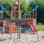 Mast climbing net in un parco giochi con scivoli e strutture in legno.