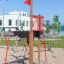 Mast climbing net nel parco giochi con bandiera rossa e sabbiera.