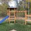 Six Angle with Suspension Bridge single slide in un parco giochi in un contesto boschivo.