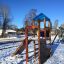 Logo Tower with Firepole playhouse with slide in un parco giochi innevato