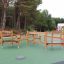Percorso a ostacoli in legno per parco giochi con corde da arrampicata e piattaforme.