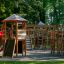 Gigantic castle with slide in un parco giochi circondato da alberi.