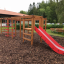 Struttura in legno per parco giochi con Activity Center with Slide in un parco.