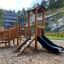 Smart Modern Nature wooden playhouse with slide in un contesto all'aperto