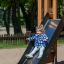 Un bambino che scivola su Logo Modern Nature playhouse with slide.