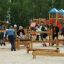 Bambini e adulti che giocano sull'attrezzatura da parco giochi Balance all'aperto.