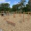Horizontal Wooden Ladder Nature in un parco giochi per bambini circondato da trucioli di legno.