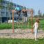 Bambini che si arrampicano e giocano su un V-shape Net wooden playhouse in un parco.