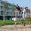Bambini che giocano su V-shape Net wooden playhouse in un parco.