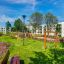 ALT: Moderno parco giochi con V-shape Net wooden playhouse in un'area residenziale.
