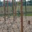 Casetta gioco Net a forma di V in legno per bambini nel parco giochi.