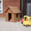Nature Playhouse in legno con macchinine in un parco giochi.