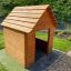 Nature Playhouse realizzato con assi di legno in un cortile erboso.