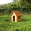 Nature Playhouse in legno in un giardino erboso.