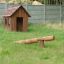 Nature Playhouse in un cortile erboso con un'altalena in legno.