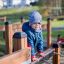 Bambino che gioca sul parco giochi in legno Trapezoidal.