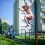 Ragazza che salta sopra le attrezzature da parco giochi Trapezoidal in una zona residenziale.