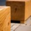 Panchine in legno Cube su una pavimentazione in pietra vicino all'acqua.