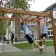 Bambini che giocano su Horizontal Ladder wooden ladder in un parco giochi scolastico.