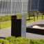 Oxford bin in un moderno contesto di parco con panchine e vegetazione.