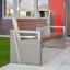 Moderno Chicago Bench con design in cemento e legno vicino all'ingresso di un edificio.