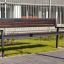 Oxford Bench, panchina moderna da parco in legno scuro con struttura in metallo in un contesto urbano.